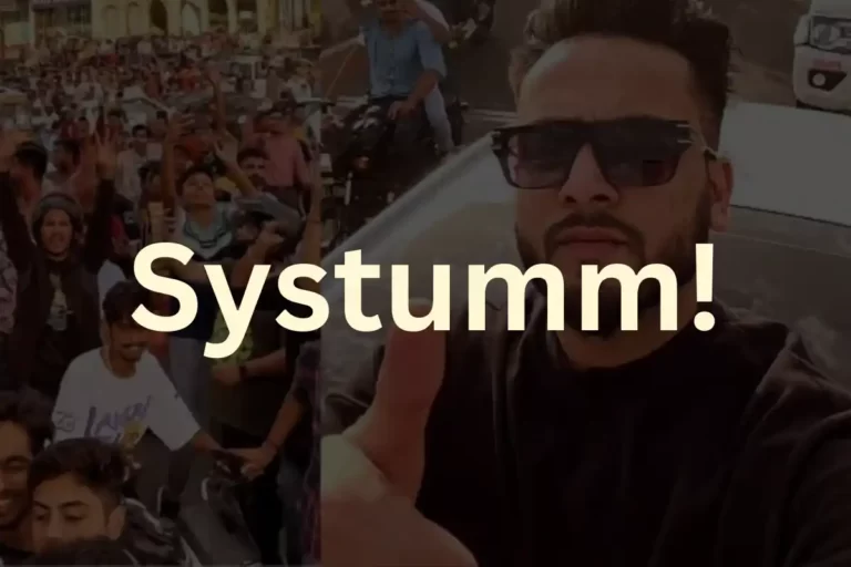 Elvish Yadav, a popular Indian YouTuber and Bigg Boss OTT contestant, is in an open roof car waving his fans on the road during a meet-up visit in Jaipur. The text “Systumm!” is written in large letters above him.
