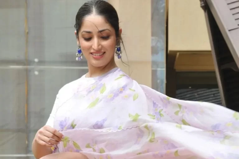 Yami Gautam is radiantly showcasing a floral saree, adorned in traditional Indian attire, exuding happiness with a bright smile.